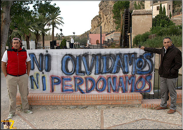 Dos dirigentes de Izquierda Unida junto a una de las pancartas deplegadas en el Parque de Las Norias