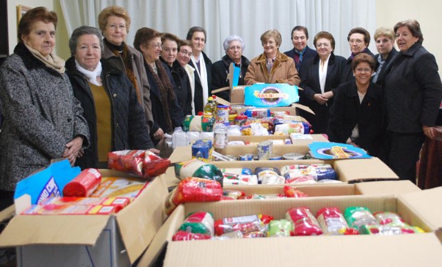 Un grupo de mujeres pertenecientes a este colectivo abaranero junto a algunos de los alimentos recogidos el pasado año.